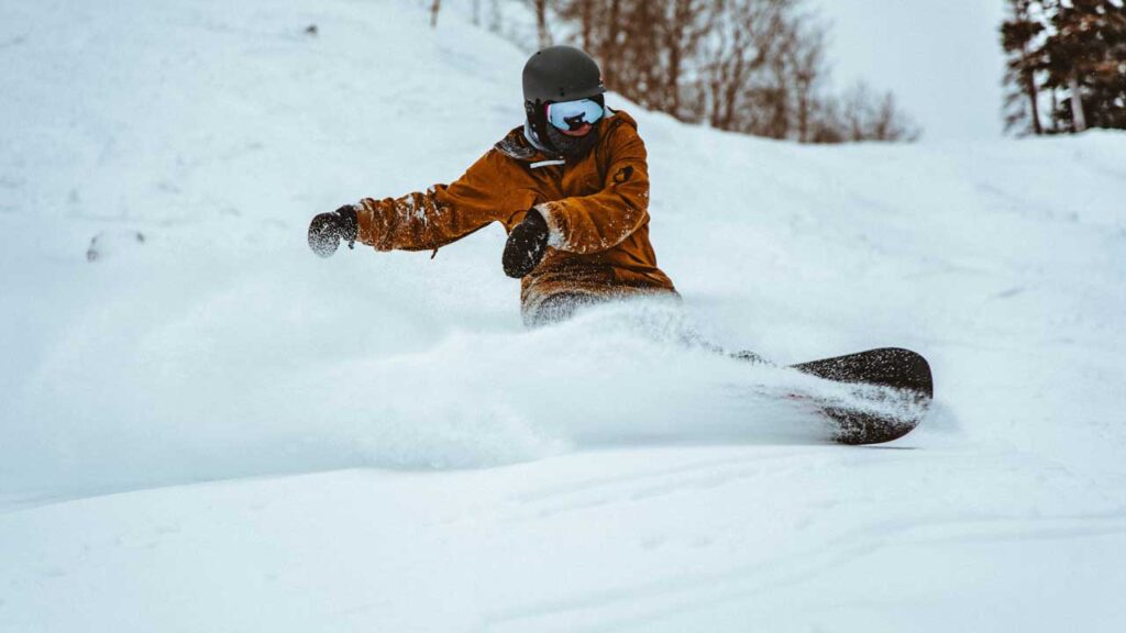 A snowboarder sprays snow during a run