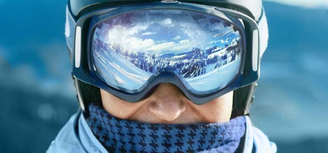 Image of man with reflective ski goggles wearing multiple layers to wear when skiing