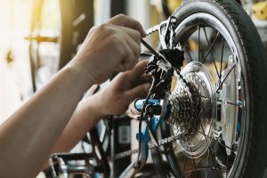 The professional adjusting a derailleur on a new bike to address any potential issues.