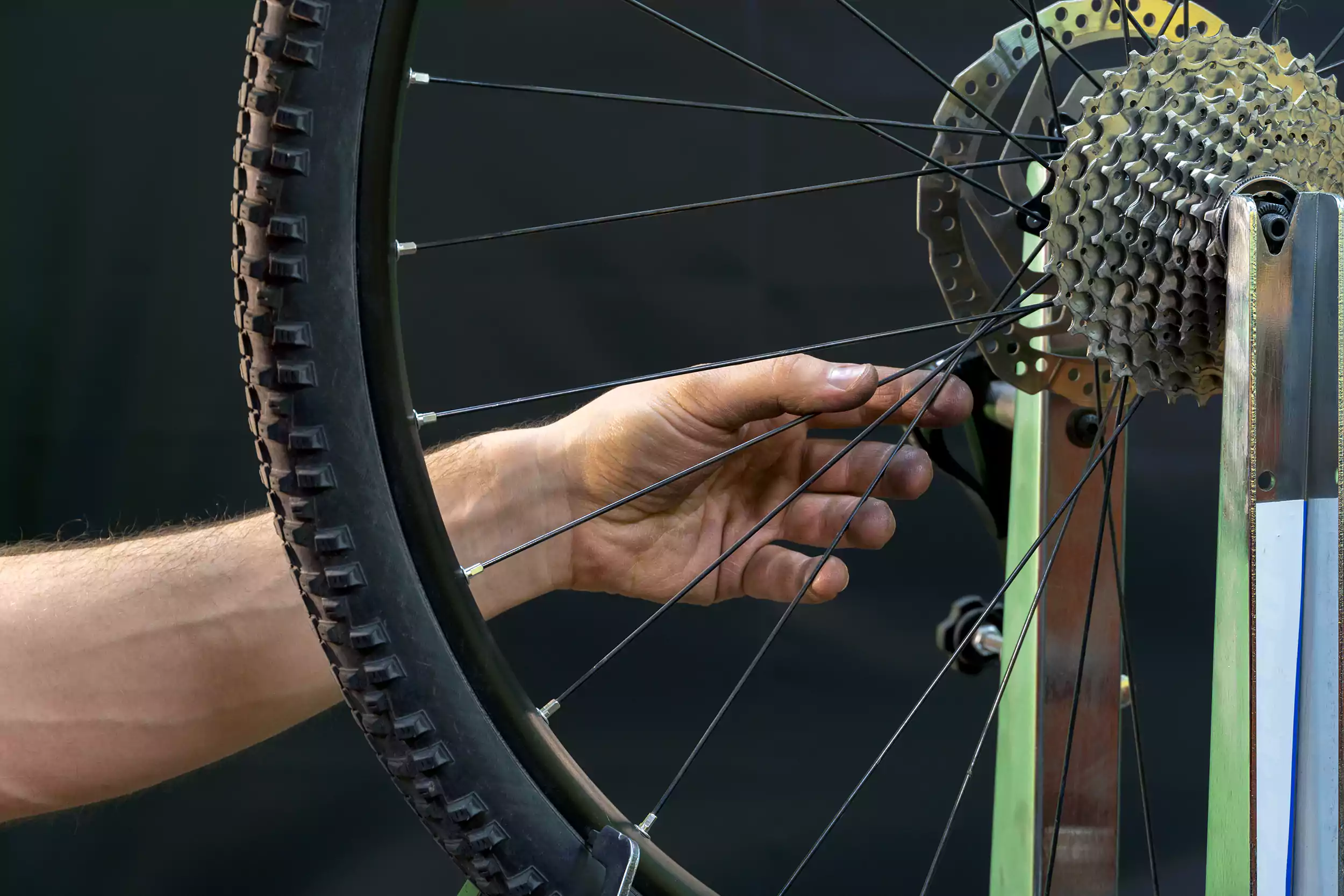 An image of a hand inspecting a bicycle wheel